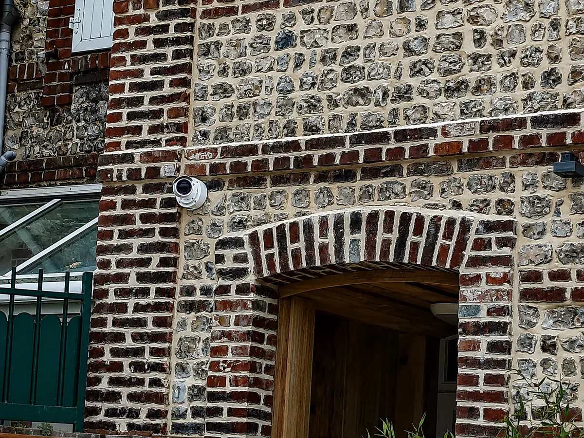 Caméra de vidéosurveillance sur une façade en pierre normande